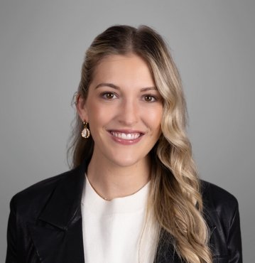 Molly Brazil, Family Law Attorney at Brazil Family Law, smiling confidently against a gray backdrop.