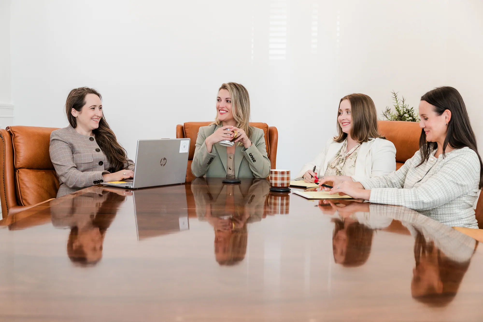 Four Brazil Family Law attorneys talking around the conference table in Winston-Salem (staged photo)