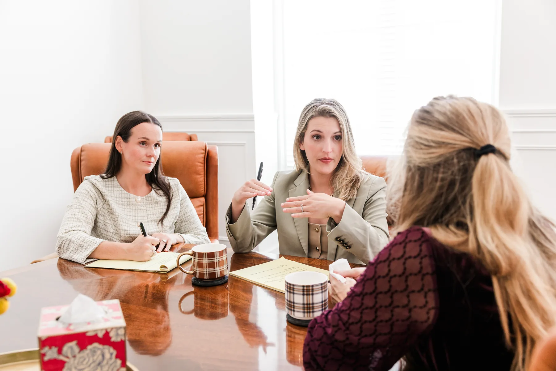 Two Brazil Family Law attorneys meeting with a client at the conference table in Winston-Salem (staged photo)